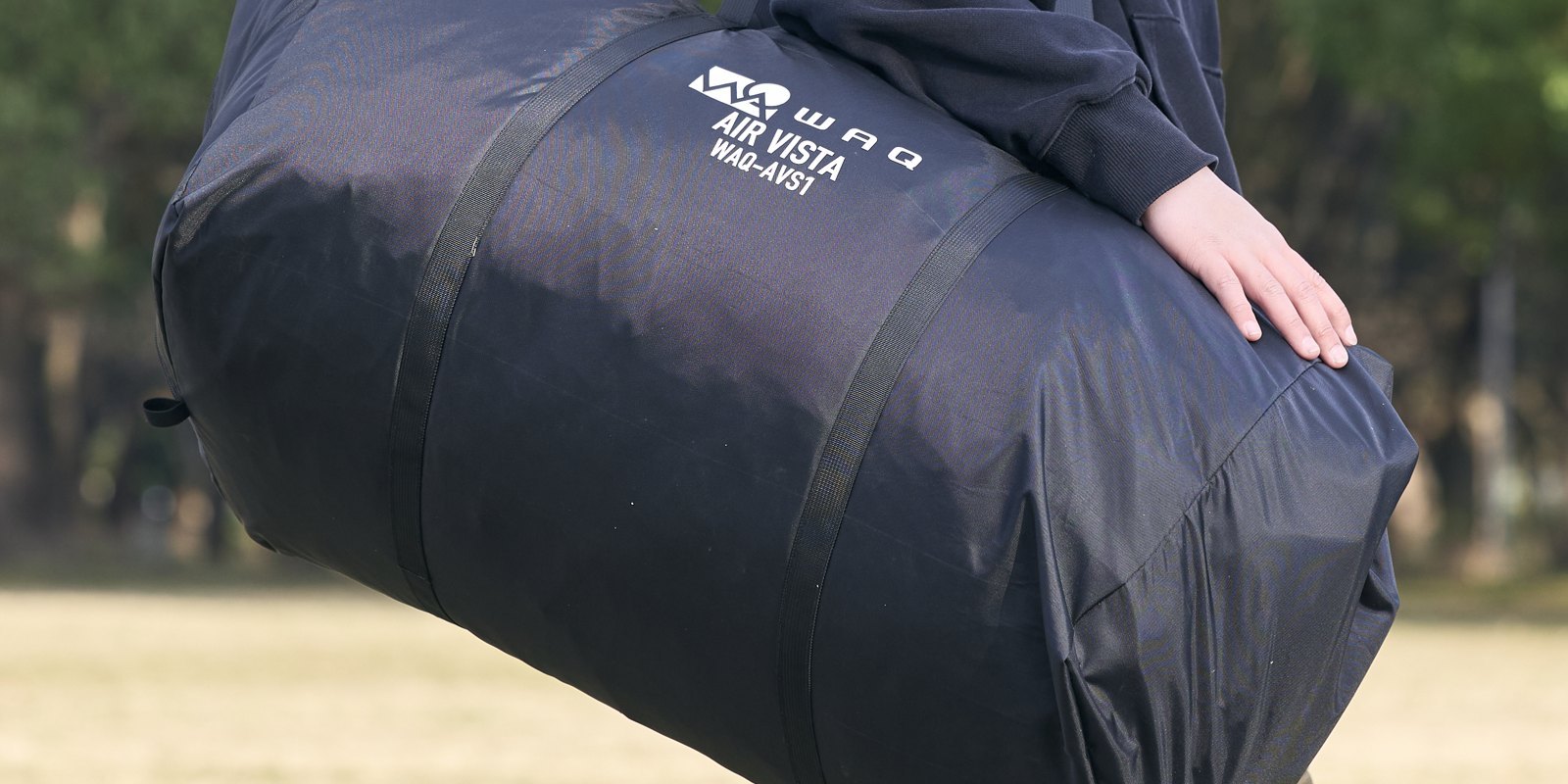 AIR VISTA のロゴが入った黒い収納袋を抱えて運ぶ様子